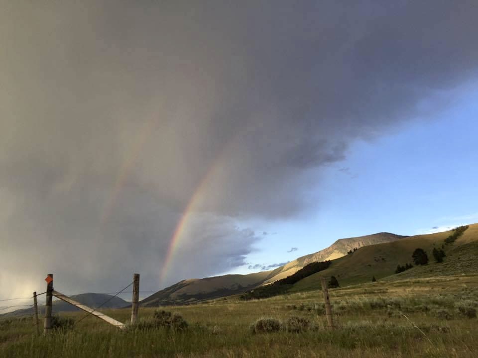 A half double-rainbow emerging from clouds